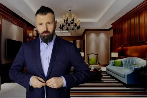 Mężczyzna w garniturze w eleganckim wnętrzu, gotowy do pracy. Dowiedz się, jak zostać agentem nieruchomości i osiągnąć sukces.